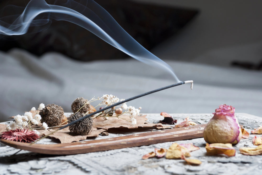 Fragrant mist rising from incense stick on ashcatcher 