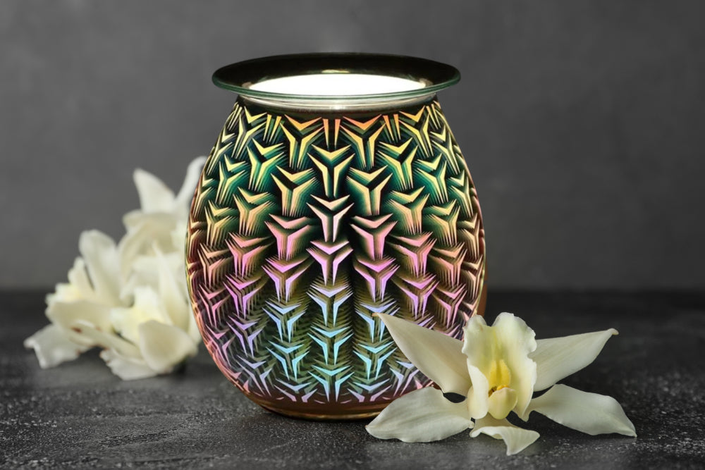 3D geometric design electric wax burner lamp on tabletop lighted up illuminating adjacent flowers