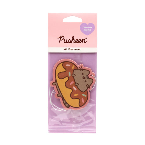 A front view of a chocolate-scented air freshener featuring Pusheen the grey cat peeking out of a chocolate-frosted doughnut with colourful sprinkles, presented in pink and purple retail packaging.