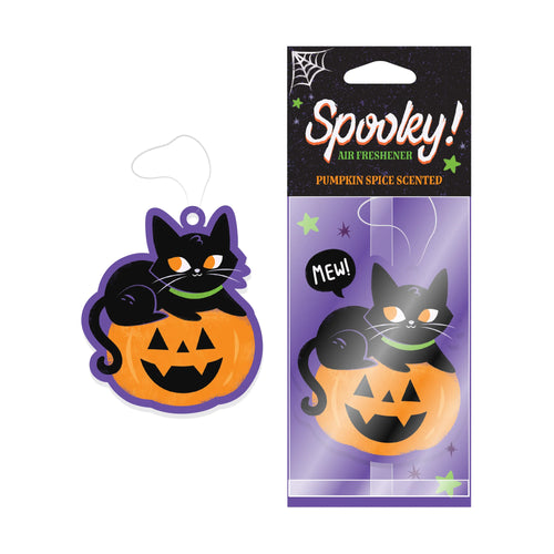 Pumpkin Spice Scented black cat and carved pumpkin air freshener, featuring a green collar and purple outline. The Halloween themed product is displayed unwrapped, next to its retail packaging showing 'Spooky!' text, a spiderweb, and stars.