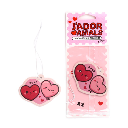 Front view of a pink double heart chocolate air freshener. One heart is dark pink and winking, the other light pink and shy, both featuring 'XOXO' and 'XX' text. It is displayed unpackaged with a white string and also in its pink polka dot retail packaging that reads 'J'ADORAMALS Chocolate Air Freshener'.