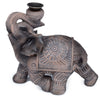 Angled view of a dark brown wood effect elephant backflow incense burner, featuring ornate decorative patterns, a raised trunk, and a metallic incense holder.