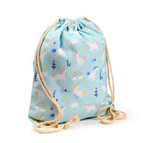 Angled view of an upright light blue canvas drawstring bag, featuring a pattern of white unicorns, colourful rainbows, and clouds, with natural rope drawstrings.
