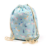 Light blue drawstring canvas bag, upright and showcasing a vibrant unicorn, rainbow, and cloud pattern, with natural rope drawstrings.