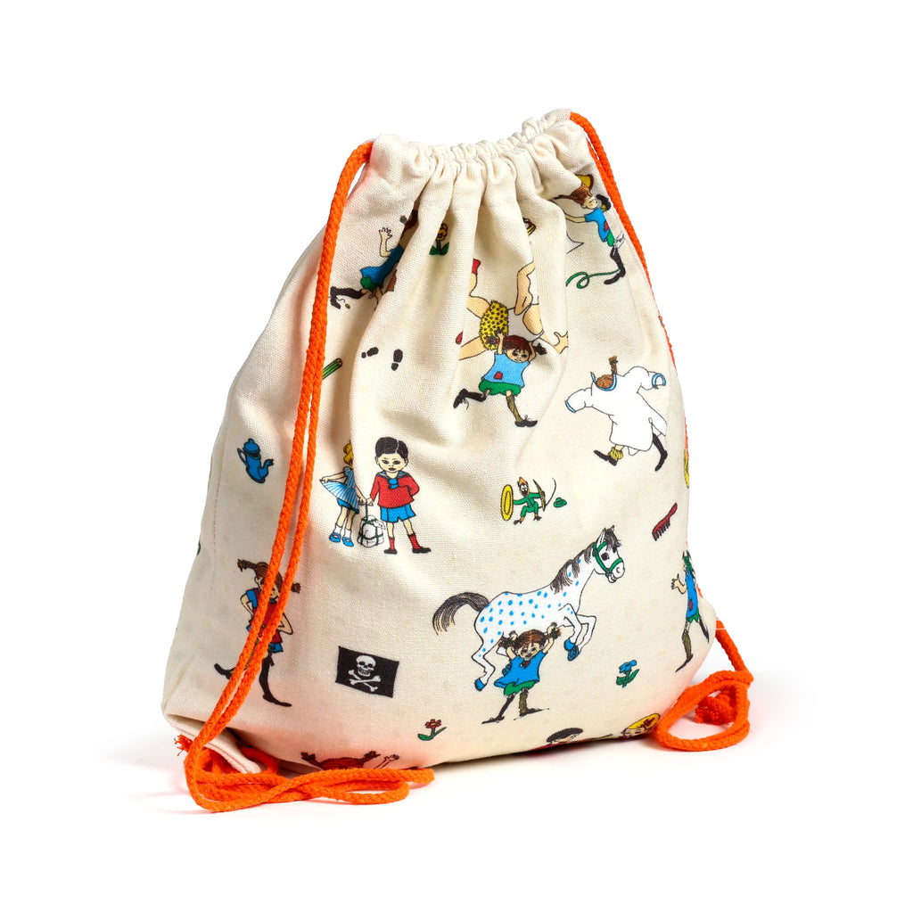Angled view of a cream canvas drawstring bag, decorated with colourful Pippi Longstocking illustrations of characters and a spotted horse, and bright orange drawstrings.