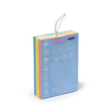 Angled view of a rectangular soap sponge package with a white rope handle, displaying 'Unicorn Magic' text, product information icons, and a rainbow-coloured stripe down the side.