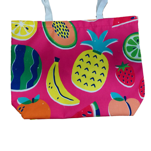 Front view of a pink polyester beach bag featuring a vibrant summer fruit pattern, including pineapples, bananas, watermelon slices, strawberries, and citrus fruit sections, with white fabric handles.