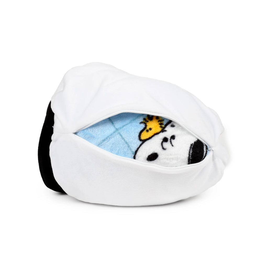Angled view of a white Snoopy plush toy, partially unzipped on the side, revealing a blue travel blanket featuring Snoopy and Woodstock.