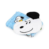 Angled view of a white Snoopy plush toy with black ears and facial features, resting on a folded light blue travel blanket featuring an embroidered sleepy Snoopy character.