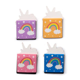 Overhead view of a set of four magnetic bookmarks, each shaped with a white unicorn head top. The rectangular bases are coloured purple, orange, pink, and blue, and each displays a rainbow, white clouds, stars, and dots.