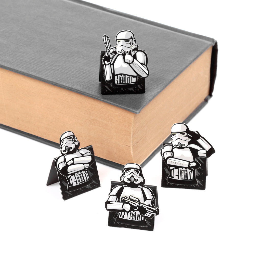 Set of four magnetic shaped Original Stormtrooper bookmarks, displayed on and around a closed grey book.