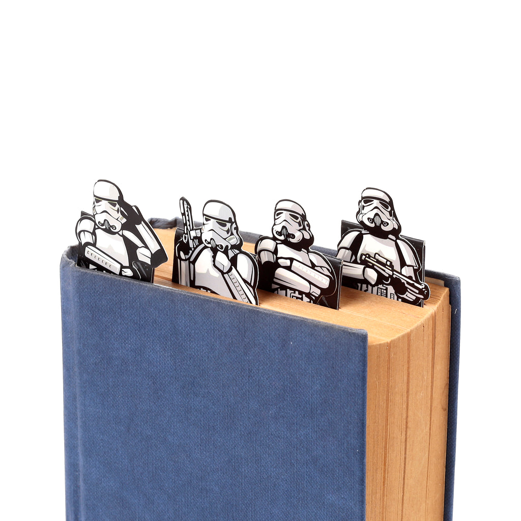 Angled view of four Stormtrooper shaped bookmarks inserted into a blue-covered book.