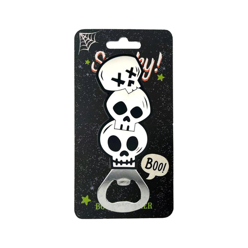 Front view of a PVC Spooky Skulls bottle opener on its black retail packaging, featuring three stacked white PVC skulls and a metallic opener section. The packaging shows 'Spooky!' text, a spiderweb, green stars, and a 'Boo!' speech bubble.