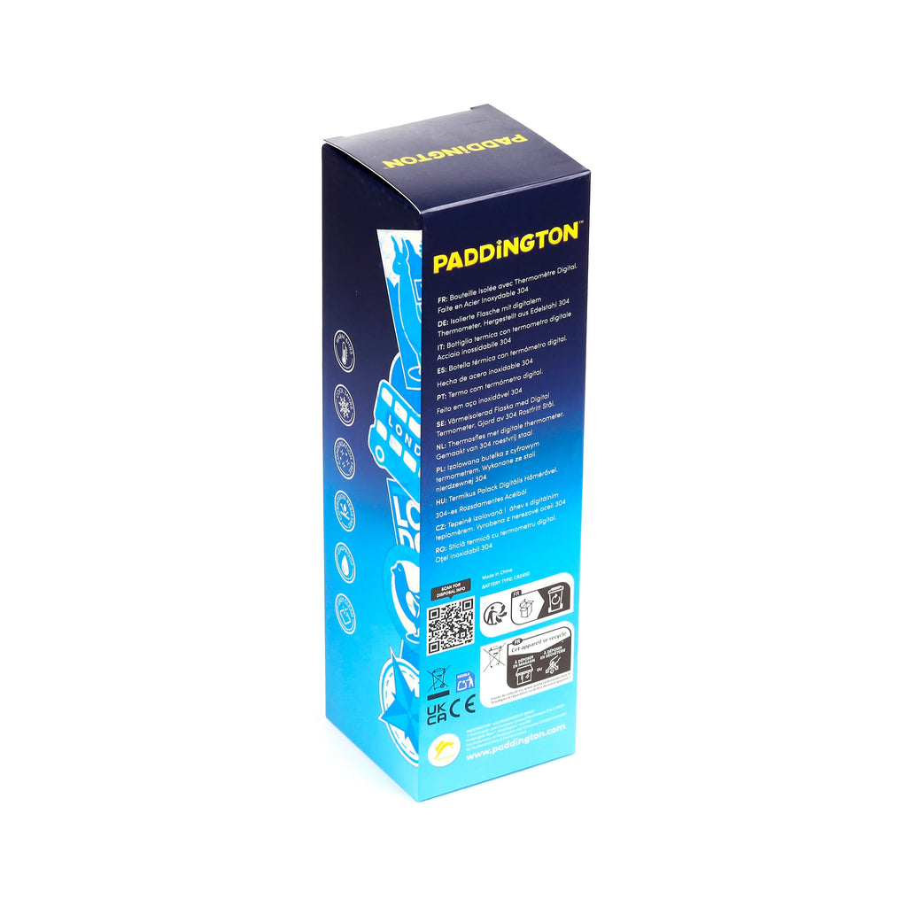 Angled view of a dark blue packaging box for a Paddington Bear insulated drinks bottle with digital thermometer. The box displays yellow 'PADDINGTON' text, feature icons, multi-lingual product details, including 304 stainless steel, and QR codes.