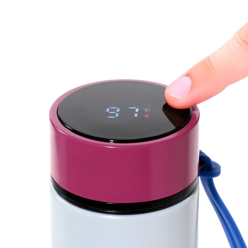 Close-up of a finger pressing the digital temperature display on a fuchsia insulated drinks bottle lid, showing 97°C. A blue carry strap and light blue bottle body are visible.
