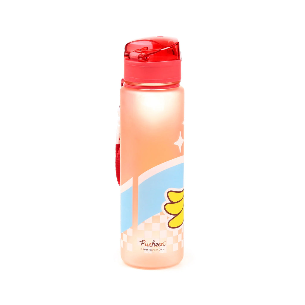 Front view of a translucent peachy pink pop top water bottle with a red lid, featuring a Pusheen and banana fruit design, with a red strap visible on the side.