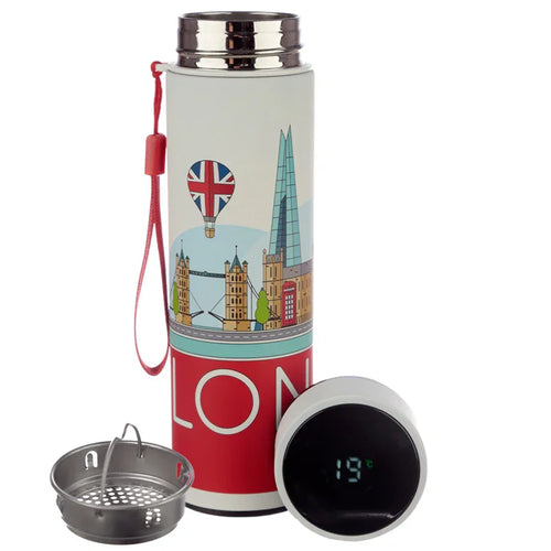 Angled view of a white stainless steel insulated drinks bottle with a London landmarks design, including Tower Bridge, The Shard, and a Union Jack hot air balloon. It features a red lanyard, a detached digital thermometer lid displaying 19°C, and a separate metallic tea infuser.