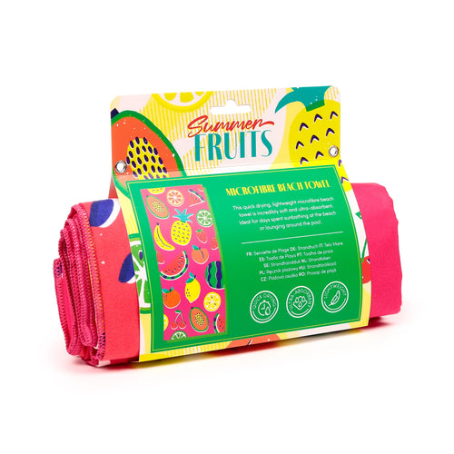 Angled view of a rolled vibrant pink microfibre beach towel, presented in colourful 'Summer Fruits' retail packaging depicting various fruit illustrations.