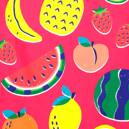 Close-up of a microfibre beach towel showing a vibrant summer fruits pattern. The design features colourful bananas, pineapples, strawberries, watermelon slices, peaches, and lemons on a bright pink background.