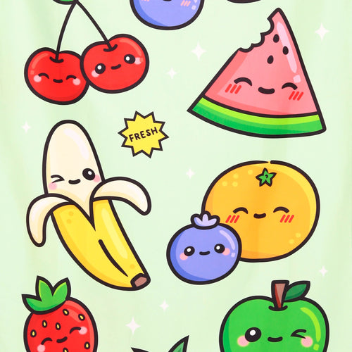 Close-up of a microfibre beach towel displaying a light green background with a playful 'Foodiemals' summer fruit pattern, including cartoon cherries, a bitten watermelon slice, peeled banana, blueberry, orange, strawberry, and a winking green apple, with a yellow 'FRESH' starburst.
