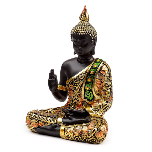 Angled view of a black Thai Buddha meditation figurine, seated with a raised hand, featuring elaborate gold, orange, and green leaf-patterned robes, on a white background.