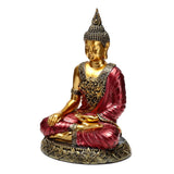 Front view of a red and gold Thai Buddha figurine, sitting in a meditative pose with intricate golden patterns on its attire and base.