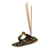 Angled view of an antique gold-coloured Buddha hand incense holder, intricately decorated with henna-style patterns, holding three light brown incense sticks.