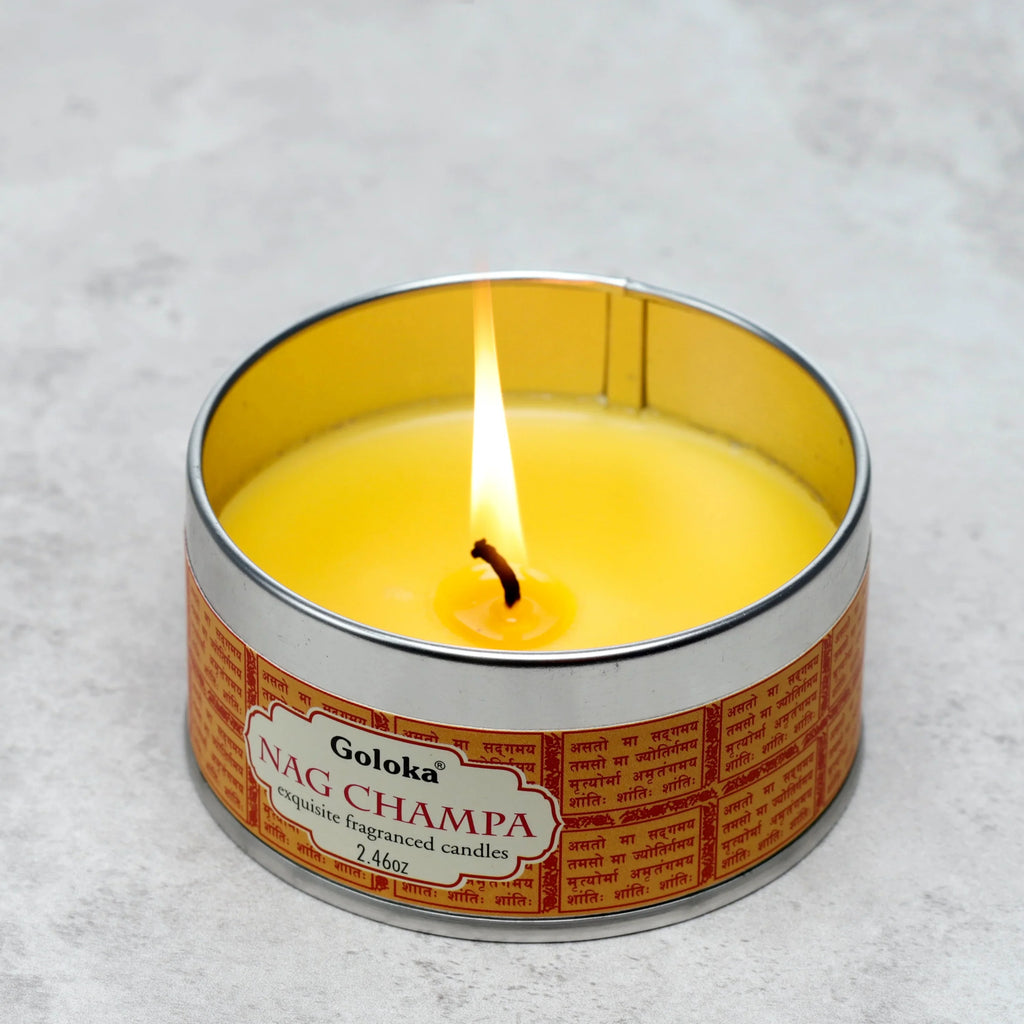 Angled view of a lit Goloka Nag Champa fragranced wax candle in a silver-coloured tin, featuring yellow wax and a reddish-orange label.