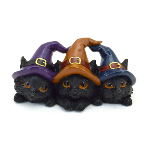 Front view of three black Witches Cats, lined up, wearing pointed hats in purple, brown, and dark blue, each with gold buckles and striking amber eyes.