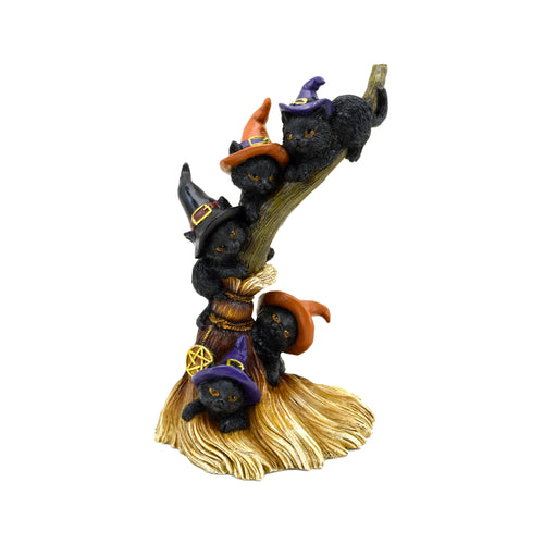 Angled view of a Witches Cat ornamental figurine, featuring five black cats wearing purple, orange, and black witches' hats, climbing a gnarled broomstick with golden bristles and a golden pentagram charm.
