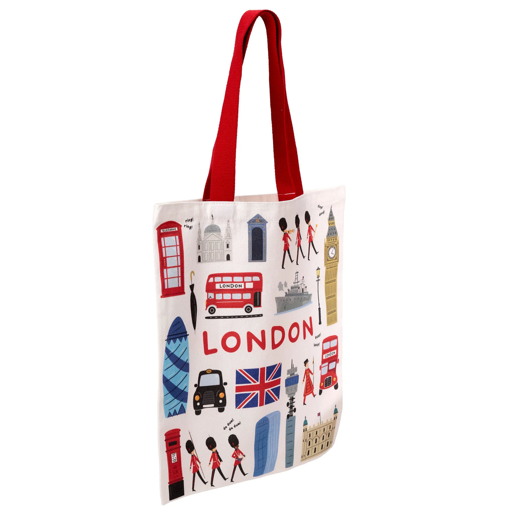 Front of a cream shopping tote bag with red handles, featuring a colourful cartoon illustration of London landmarks, including a red double-decker bus, Big Ben, and Royal Guards, with prominent 'LONDON' text.