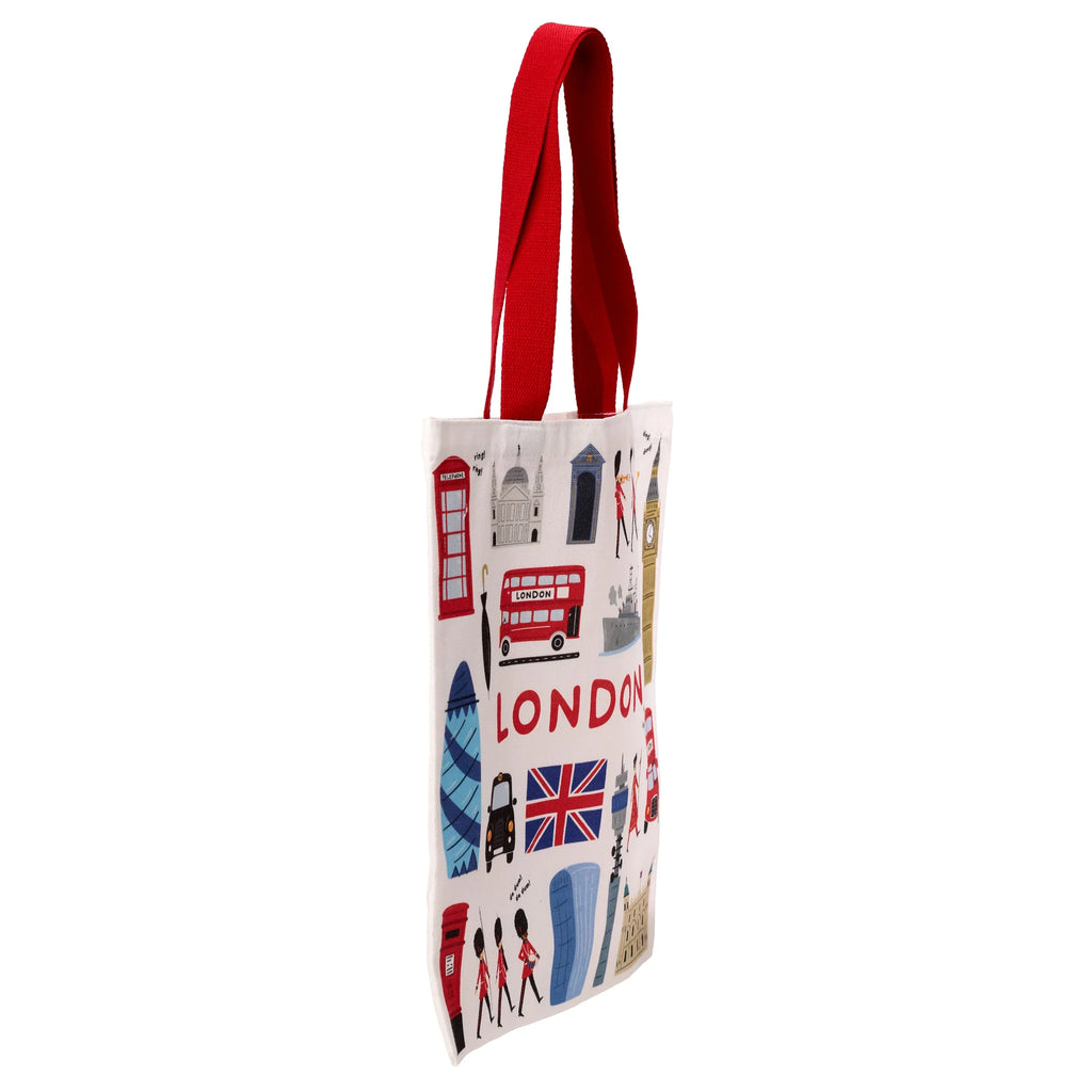 Angled view of a white London souvenir shopping tote bag with red handles, featuring colourful illustrations of Big Ben, a red double-decker bus, and the word 'LONDON'.