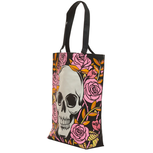 Angled view of a black cotton shopping bag, featuring a prominent light grey skull surrounded by vibrant pink roses with yellow and orange leaves.