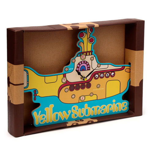 Front-angled view of a decorative Yellow Submarine shaped clock, predominantly yellow and blue, featuring a clock face with numbered circles, black hour and minute hands, and a gold second hand, presented within its brown cardboard packaging.