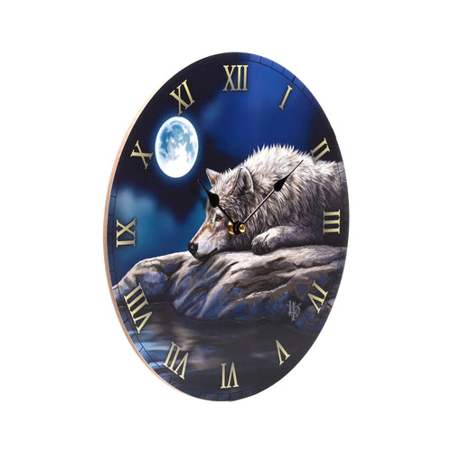Angled view of a round wall clock showing a tranquil grey wolf resting on rocks by moonlit water under a bright full moon and deep blue night sky, with gold Roman numerals.