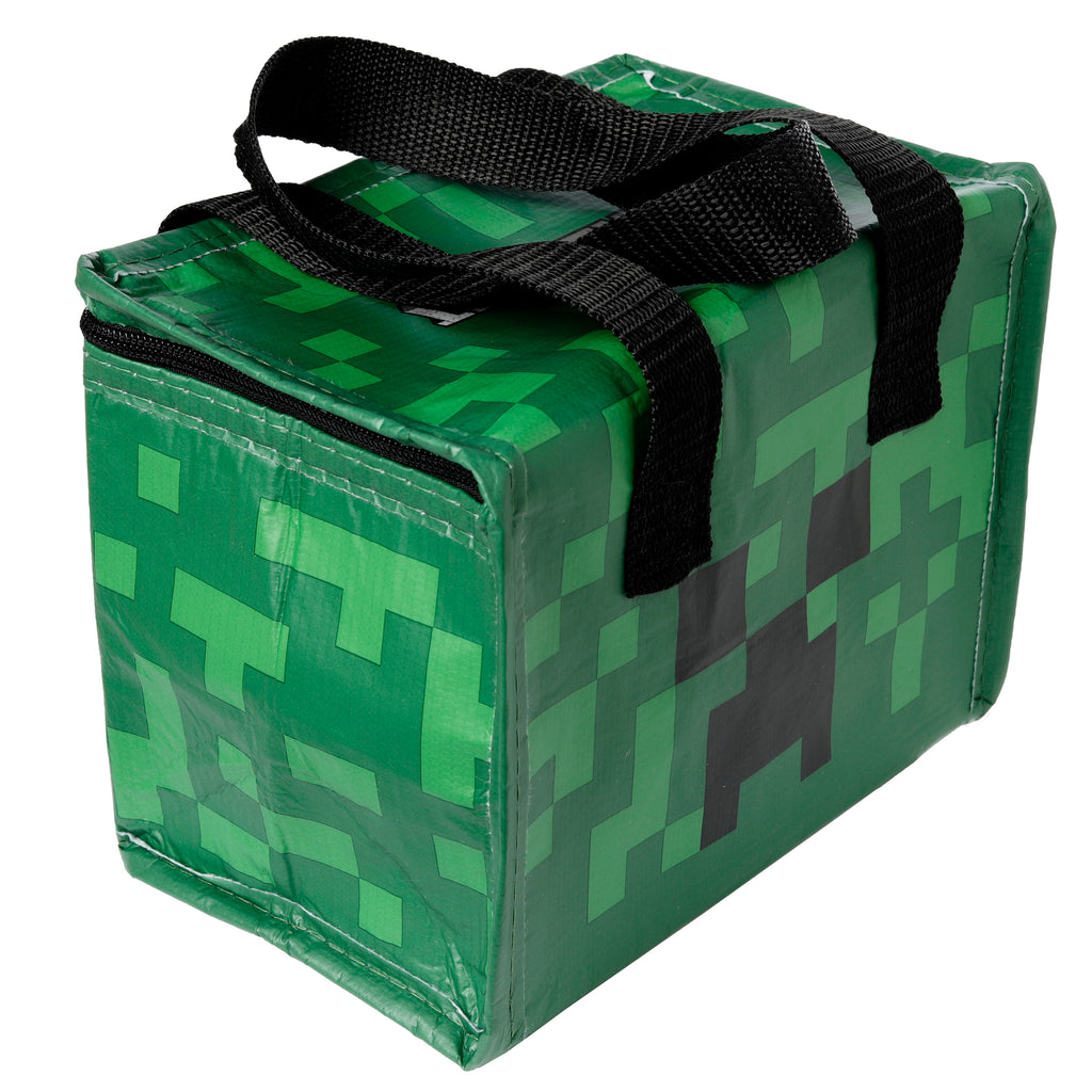 Angled view of a green cool bag, displaying a pixelated Minecraft Creeper face design on its side, with a black zip fastening and black fabric carry handles.