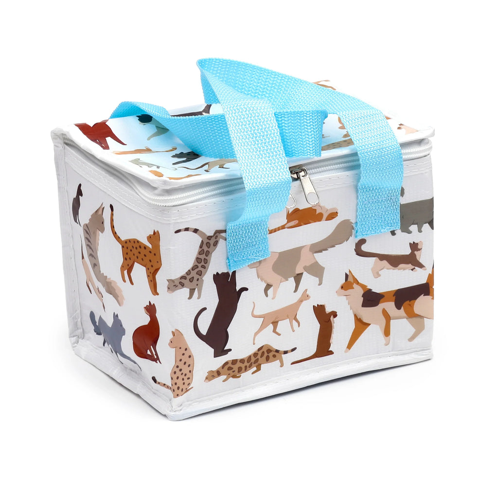 Angled view of a white cool bag featuring a colourful cat illustration pattern, light blue webbing handles, and a zip closure.