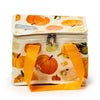 Angled view of an Autumn Harvest cool bag, featuring a cream fabric with a colourful pumpkin and squash pattern, an orange fabric handle, and a zipped closure with two metal pulls.