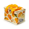 Angled view of an Autumn Harvest cool bag, featuring an orange, cream, and green pumpkin and gourd pattern, with bright orange webbing handles and a zip closure.