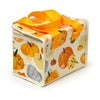 Angled view of an Autumn Harvest RPET cool bag with orange fabric handles, featuring a pattern of orange, cream, and grey pumpkins and gourds, and a zip fastening.