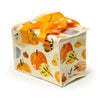 Angled view of an Autumn Harvest RPET cool bag, featuring an autumn-themed pattern of various coloured gourds and pumpkins on a cream background, with bright orange handles and a white zip closure.