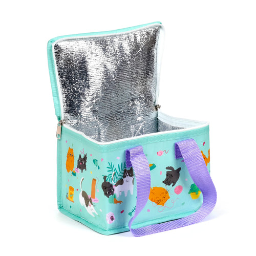 Angled view of an open mint green cool bag, decorated with playful cartoon cats, showing its silver insulated lining and purple woven fabric handles.