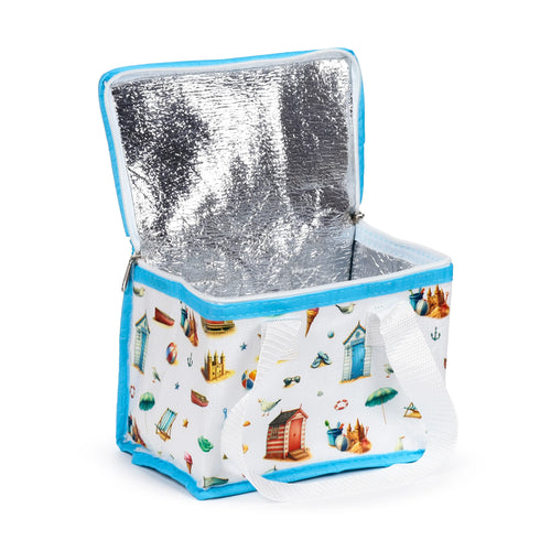 Angled view of an open white cool bag with a vibrant coastal print featuring beach huts and sandcastles, light blue trim, white carry strap, and silver insulated lining.