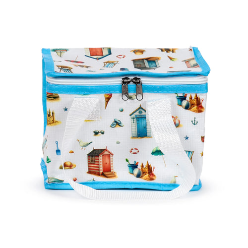 Front view of a white Coastal RPET cool bag featuring a vibrant beach-themed pattern including colourful beach huts, sandcastles, ice cream cones, and seagulls. It has light blue trim and white fabric handles.