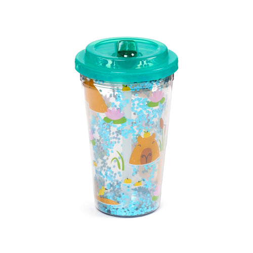 Angled view of a clear, shatterproof double-walled cup with a teal lid and a visible straw. The cup features a capybara design with blue glitter, pink water lilies, and green foliage.