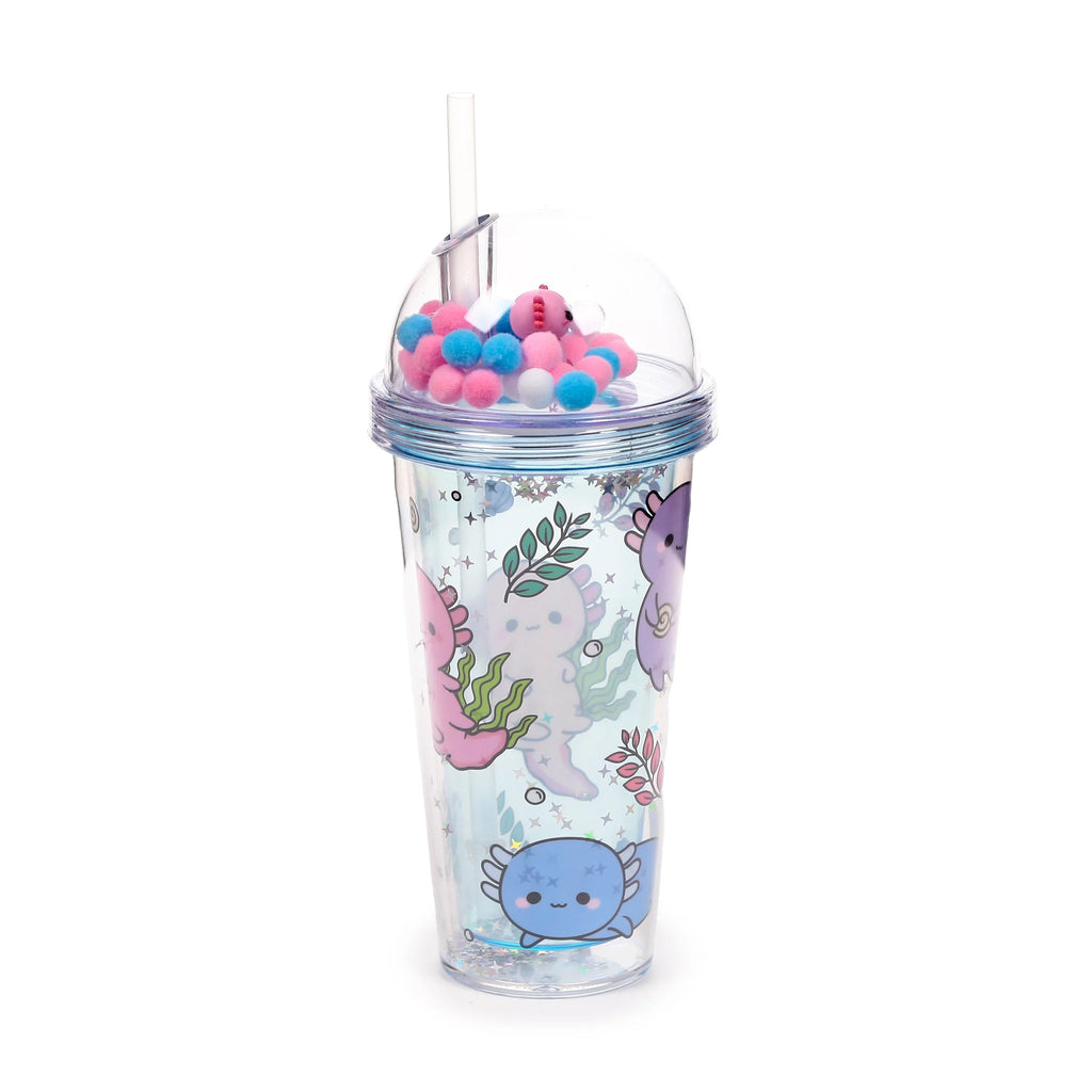 Angled view of a clear double-walled cup with a domed lid, clear straw, and internal pink, blue, and white pom-poms plus a pink axolotl charm. The cup features colourful cartoon axolotl illustrations in pink, purple, and blue, surrounded by seaweed and stars, with glitter between the walls.
