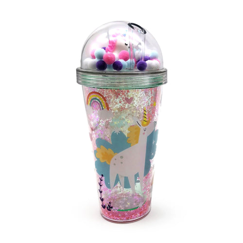Angled view of a double-walled cup with pink iridescent glitter, a unicorn and rainbow design, and a clear domed lid holding a mini unicorn and colourful pompoms.