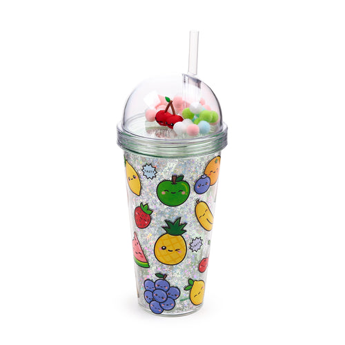 Angled view of a clear double-walled cup with sparkling glitter, adorned with various cartoon fruit illustrations. It features a transparent domed lid from which a clear straw emerges, and inside the lid are colourful pom-poms and a red cherry charm.
