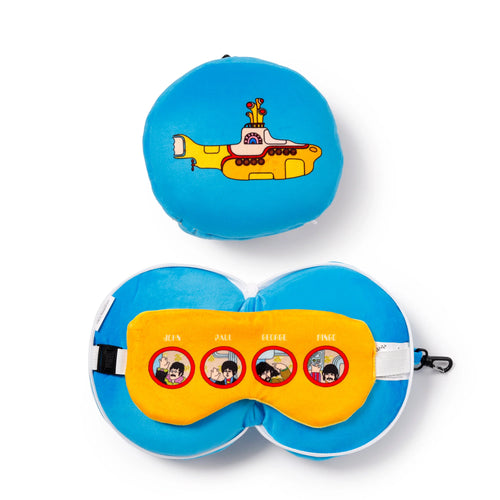 Overhead view of a Yellow Submarine Relaxeazzz plush travel pillow and eye mask set, shown on a white background. The set features a blue round cushion with a yellow submarine graphic, and a blue plush travel pillow displayed open with its yellow eye mask. The eye mask depicts cartoon portraits of John, Paul, George, and Ringo, and includes a black adjustable strap and a carabiner clip.