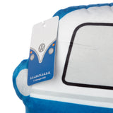 Angled close-up of a blue and white plush Volkswagen T1 Camper Bus cushion, showing its soft texture, a black outline resembling a window on its side, and a white product tag displaying a graphic of the bus's front with 'Volkswagen' text.